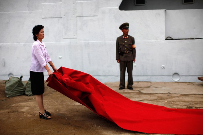 Một nữ nhân viên Triều Tiên đang chuẩn bị thảm đỏ đón khách trong lễ khánh thành tàu du lịch đường dài Mangyongbyong tại thành phố Rason.
